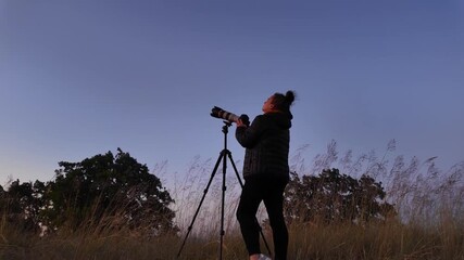 Wall Mural - amateur astronomer using camera and lens for photographing stars, moon, planets and other celestial 