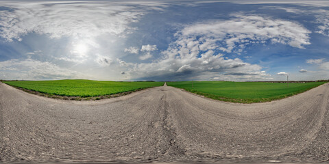 Wall Mural - spherical 360 hdri panorama on old asphalt road with cracks with clouds and sun on blue sky in equir