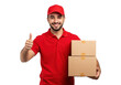 © stock.metket.com - A smiling delivery man in a red uniform and cap gives a thumbs up while holding two cardboard boxes, isolated on transparent background