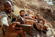 © Marko Geber - Group of young hikers taking a moment to take a selfie with a smart phone while taking a break from hiking