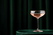 © A2Z AI  - Elegant pink cocktail in coupe glass on velvet table against a dark green curtain backdrop, perfect for a celebratory toast or a sophisticated evening drink.