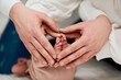 © Minet - A close up of parents hands forming a heart around their newborns tiny feet, symbolizing love, family, and new beginnings.