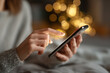 © Wimstock - A detailed close-up showing a hand interacting with a smartphone in a softly lit indoor setting.