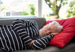 © luciano - Closeup portrait of sleeping senior bearded man, peaceful grandfather resting on sofa at home, enjoying midday nap in living room. Seniors lifestyle concept