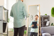 © Studio Romantic - Portrait of young businessman wearing shirt looking at the mirror preparing for work interview standing at home and holding documents in hands. Man employee preparing for job conference.