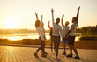 © Studio Romantic - Happy gesture of runners with hands up, excited athletes group standing in circle to celebrate success of joint sports training outdoors. Team workout in morning sunlight. Marathon, win concept