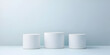© Asraful - Three white cylindrical pedestals on light blue background 1