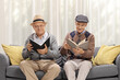 © Ljupco Smokovski - Elderly men sitting on a sofa and reading