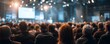 © Rifqi - Large crowd of people attending a conference or seminar, seen from behind with stage lights. Concept for business presentations, corporate events, and leadership summits for senior executive officers