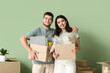 © Pixel-Shot - Young happy couple holding belongings in their new house