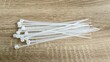 © Al-Jabbar99 - White Plastic Cable Ties on Wooden Table
