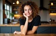 © starush - Woman with curly hair smiling at camera in modern kitchen setting