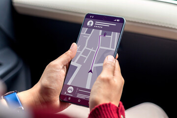 Booking taxi online concept. Woman in a car ordering taxi online using mobile app on her smartphone.