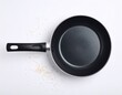 © Sadia - Non-Stick Frying Pan with Scattered Rice Grains: Kitchen Essentials on white background