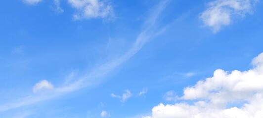 Wall Mural - Bright sky with white fluffy clouds in summer. Blue sky with clouds. Soft white clouds float in the clear blue sky. Clear blue sky, bright spring, wallpaper landscape.