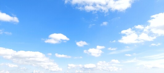 Wall Mural - Bright sky with white fluffy clouds in summer. Blue sky with clouds. Soft white clouds float in the clear blue sky. Clear blue sky, bright spring, wallpaper landscape.
