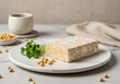 © Hesty - Fresh tempeh tepalak on a marble plate, garnished with sprouts and soybeans, with cups in the background