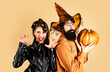 © Volodymyr - Happy couple in Halloween costume. Halloween couple with pumpkin and Halloween makeup. Man and woman in witch hat celebrating Halloween.