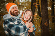 © Volodymyr - Couple in warm knitted hat and scarf hug outdoor in autumn forest. Cozy mood and autumn inspiration concept. Couple in Autumn fall mood. Man and woman near Autumn fall leaves.