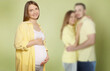 © New Africa - Surrogate mother and intended parents against olive color background, selective focus