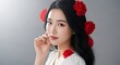© Zilan - Elegant asian woman portrait with red flowers in hair and soft makeup creating a romantic and