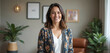 © miss irine - Friendly female clinical psychologist in therapy office, smiling warmly. Pro healer offers mental health support. Portrait in cozy clinic setting with plants and artwork.