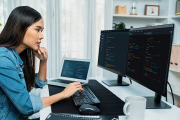 young asian in it developer creating with typing online information on pc with coding program data o