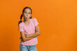 © Andrii Iemelianenko - Cheerful funny young school girl showing tongue making faces at camera, fooling around, joking, aping with silly face teasing bullying abuse. Preteen female child kid 10 years old on orange background