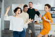 © JackF - Four adult friends dancing and singing at home. Cheerful women and men enjoy music together. Happy party people celebrating friendship