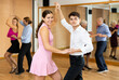 © JackF - Happy attractive young girl enjoying impassioned merengue with guy partner in latin dance class. Social dancing concept