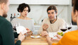 © JackF - Two married couples are having fun in cozy home atmosphere, playing card game poker. Player makes lead move and believes in luck, emotionally waiting for victory, calculate winning combination