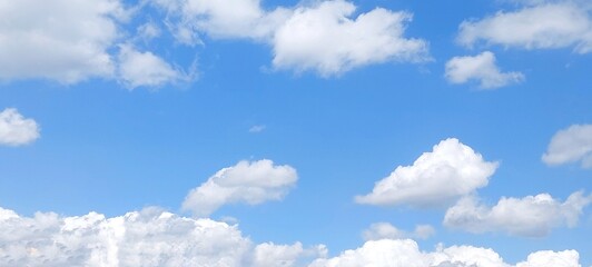 Wall Mural - Panoramic cloudscape in clear blue sky in summer. Nature sky background with fluffy clouds.