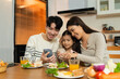 © NINENII - Family Asian spending happy time together on vacation, sitting in the kitchen.