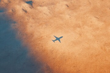 Wall Mural - abstract view of wingsuit shadow over desert ground