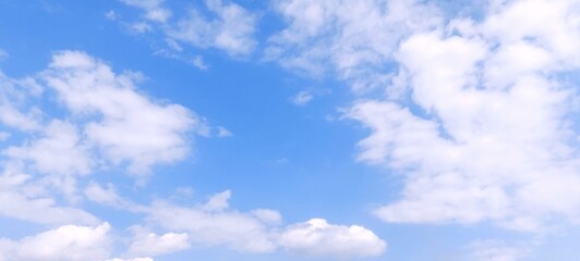 Wall Mural - White cumulus clouds in blue sky with daylight natural background. Blue sky with clouds. Soft white clouds float in the clear blue sky. Clear blue sky, bright spring, wallpaper landscape.