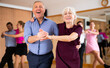© JackF - Active elderly pair practicing Latino dance in training hall during dancing-classes. Pairs training ballroom dance
