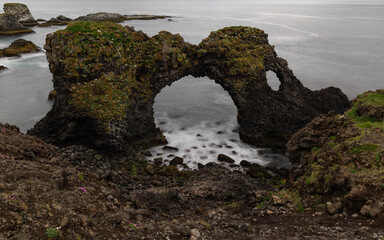 Wall Mural - Cloudy view over Gatklettur rock formation, Iceland.