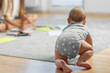 © Olha Tsiplyar - Crawling baby in polka dot onesie on floor.