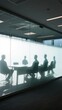 © meng - Silhouettes of people in a modern glass-walled conference room