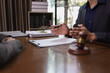 © SOMKID - Two Lawyer with Document Paper and Hammer on Wood table,  Judge's Gavel, Law, Justice Symbol, Agreement and Partnership Concept,