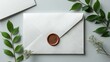 © 1989 - White envelope with copper wax seal and greenery.