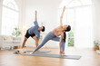 © 220 Selfmade studio - Asian Young couple practicing yoga together in bright living room with dog resting nearby, creating peaceful and healthy atmosphere for exercise and relaxation