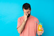 © luismolinero - Young man over holding a cocktail over isolated blue background with tired and sick expression
