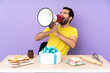 © luismolinero - Man in a table with a big cake shouting through a megaphone