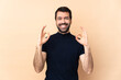 © luismolinero - Caucasian handsome man over isolated background showing an ok sign with fingers