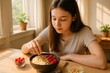 © Татьяна Евдокимова - Teenager carefully decorating a smoothie bowl with fresh bananas and raspberries, creating a nutritious and colorful breakfast in a sunlit kitchen