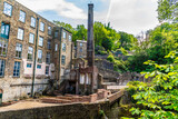 A  view towards a disused mill beside the Torrs Riverside walkway at New Mills, High Peak in the UK in summertime