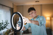 © Miljan Živković - man v-logger set up mobile phone and ring light for live streaming