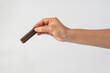 © apinya - Chocolate bar in hand on white background