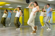 © JackF - Diligent sporty teenagers performing dynamic energetic dancing movements in modern loft studio